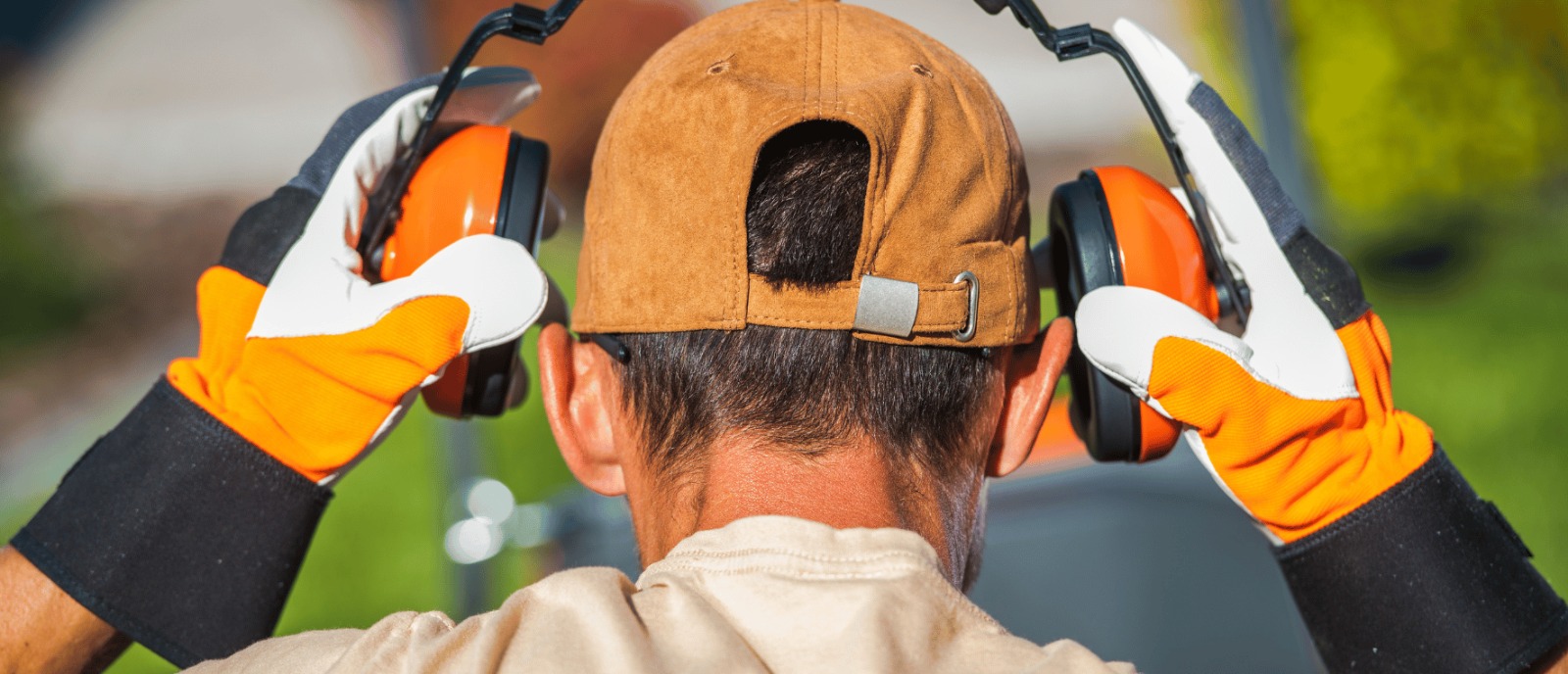 Person covering ears due to loud noise exposure hearing loss from high decibel environments.